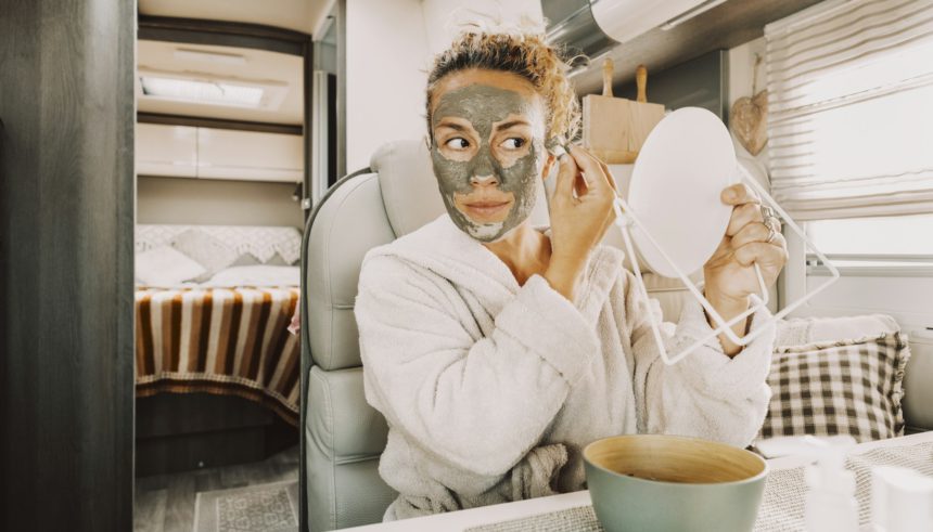 One pretty adult young woman busy in daily skin face care routine using natural green mask